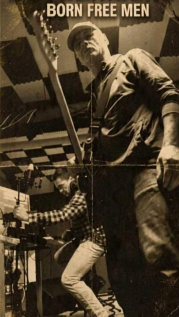 Sepia rehearsal-room poster, folded twice: one of us standing with a guitar under a checkered foam ceiling, the other bent over a microphone stand and a rack of gear. Printed title: BORN FREE MEN.
